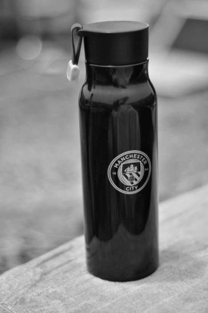 selective focus photography of manchester city sports bottle